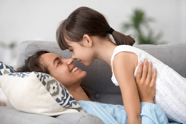 Amorosa joven mamá y poco hija relajarse en sofá abrazo — Foto de Stock