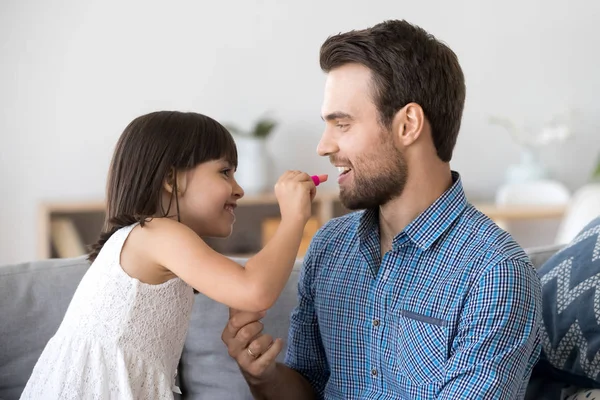 Divertida niña hacer maquillaje pintar labios para papá joven — Foto de Stock