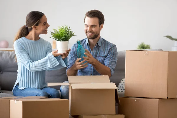 Aufgeregtes Paar packt auf Couch sitzend Kisten aus — Stockfoto