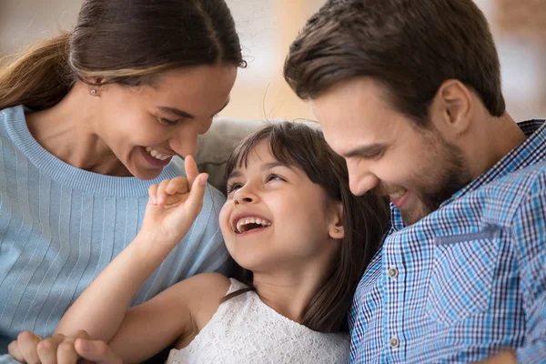Счастливая молодая семья с ребенком отдыхает, веселясь дома — стоковое фото