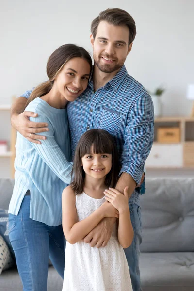 Retrato familiar de padres cariñosos abrazo posando con hija pequeña — Foto de Stock