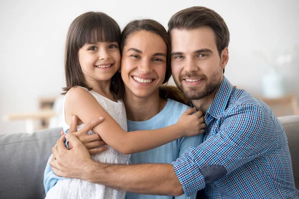 Porträt einer glücklichen Familie mit Kind, das sich umarmt und für ein Foto posiert — Stockfoto