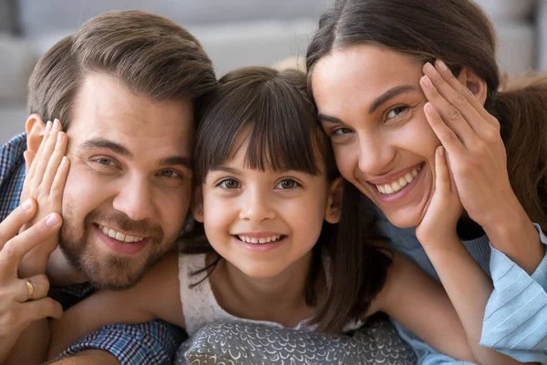 Nettes Vorschulmädchen umarmt Eltern, die für ein gemeinsames Foto posieren — Stockfoto