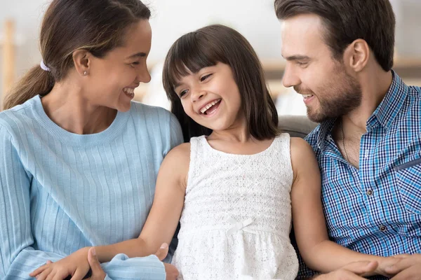 Lyckliga föräldrar slappna av på soffan med liten dotter — Stockfoto