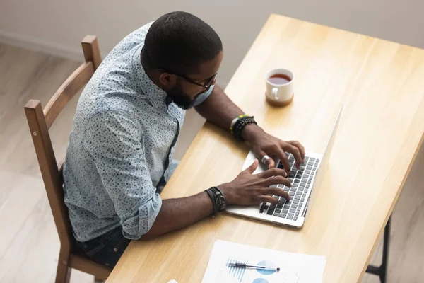 Vista dall'alto dipendente afroamericano che lavora con il computer portatile in ufficio — Foto Stock