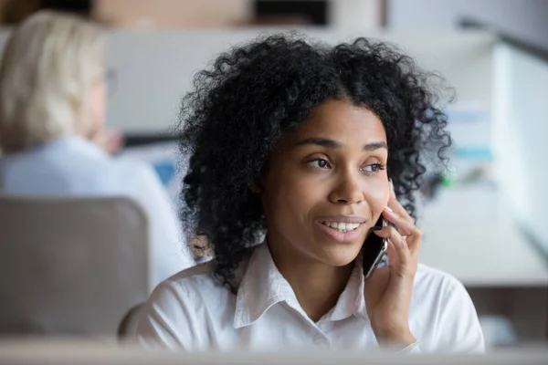 Афроамериканская деловая женщина разговаривает по телефону на рабочем месте — стоковое фото