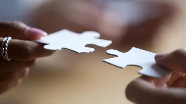 Close up multiracial business team members connecting puzzle pieces — Stock Photo, Image