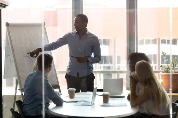 Entrenador de negocios afroamericano que presenta los resultados de gráficos en flipchart — Foto de Stock