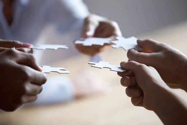 Close up members of multiracial team holding pieces of puzzle — Stock Photo, Image