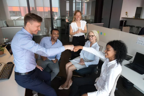 Diversos colegas puño chocando, celebrando el éxito del trabajo en equipo en la sesión informativa — Foto de Stock