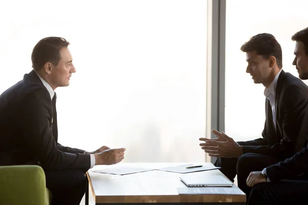 Concentrated businessmen negotiate at meeting discussing cooperation — Stock Photo, Image