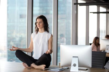 Huzurlu iş kadını uygulama yoga ofiste masada oturan