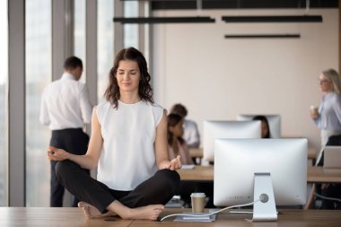 Sakin kadın çalışan uygulama yoga masada coworking alanında