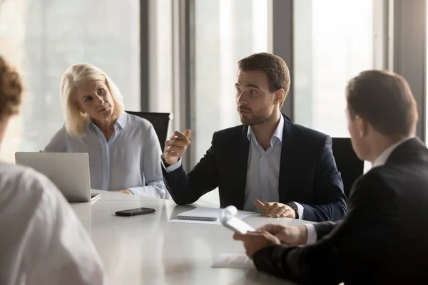 Serious colleagues brainstorm discussing project at meeting — Stock Photo, Image