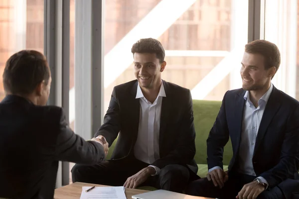 Lächelnder Geschäftspartner bei der Unterzeichnung des erfolgreichen Abkommens per Handschlag — Stockfoto