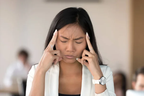疲惫的亚洲女商人在工作场所头痛 — 图库照片