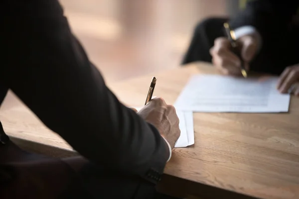 Primer plano de los socios comerciales firman contrato en la reunión — Foto de Stock