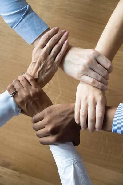 Close up multiracial business people holding each others wrists — Stock Photo, Image