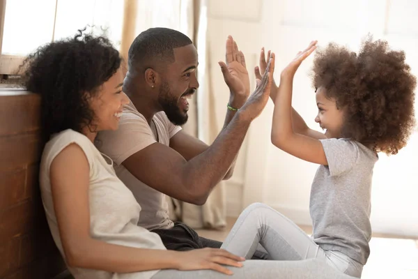 Africano niño hija dar chocar cinco a papá jugando con padres — Foto de Stock