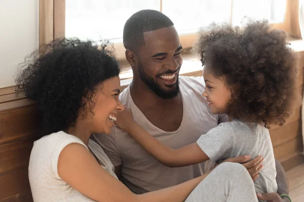Glückliche schwarze Familienbande lachend auf dem Schlafzimmerboden sitzen — Stockfoto