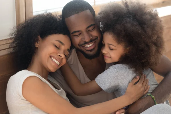 Feliz afectuosa familia afroamericana de tres lazos abrazando —  Fotos de Stock