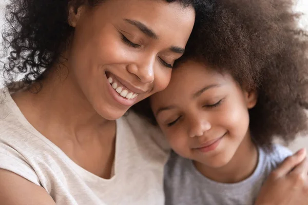 Liefdevolle jonge Afrikaanse moeder Holding omarmen schattige kleine kind dochter — Stockfoto