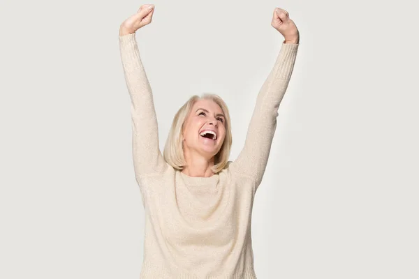 Eccitato anziana donna alzato mani tese si sente felice colpo in studio — Foto Stock