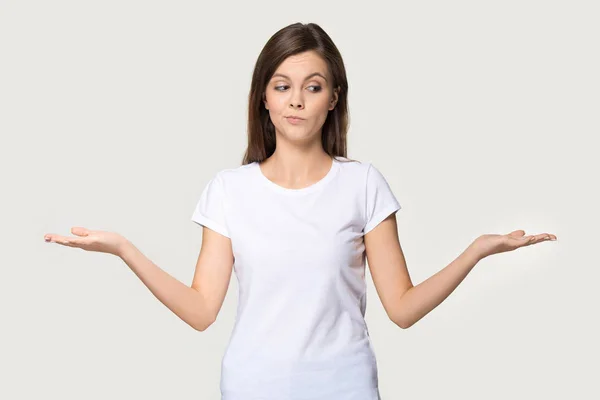 Milenniová žena natažená na rukou myšlení dělá volbu na šedém pozadí — Stock fotografie