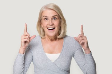 Kıdemli kadın işaret parmaklar yukarı hissediyor heyecanlı stüdyo kafa shot