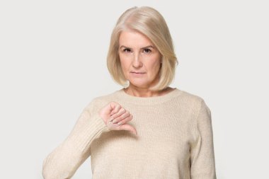 Kasvetli Olgun kadın kamera gösteren başparmak aşağı bakıyor