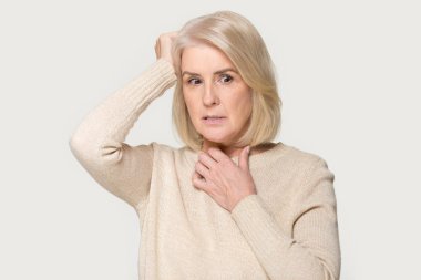 Gri stüdyo arka planda izole yaşlı kadın korkmuş yüz ifadeleri