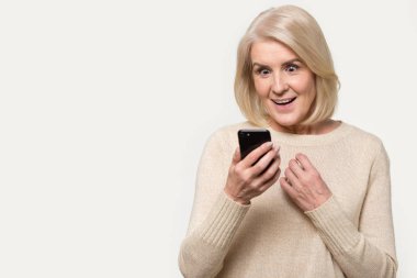 Akıllı telefon ekrana bakarak kıdemli kadın şaşırtması stüdyo shot hissediyor