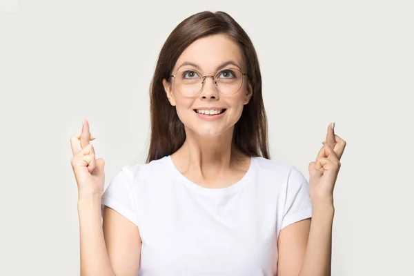 Femme comique dans des lunettes croisant les doigts demande bonne chance — Photo