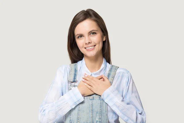 Attractive young woman holding hand on heart feels gratitude — Stock Photo, Image