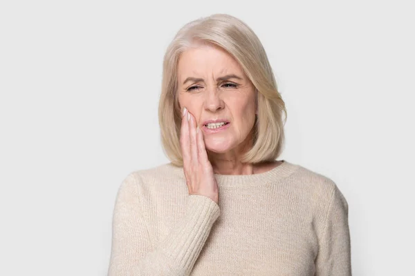 Портрет зрелая женщина касается щеки страдает от зубной боли — стоковое фото