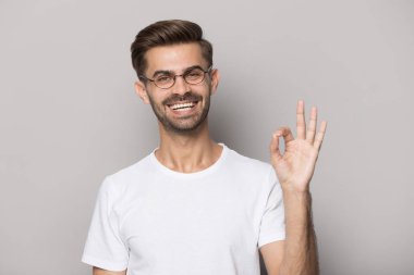 Happy guy gesturing ok sign smiling looking at camera clipart