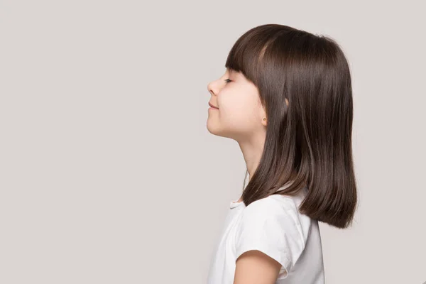 Profil des ruhigen kleinen Mädchens isoliert auf grauem Studiohintergrund — Stockfoto