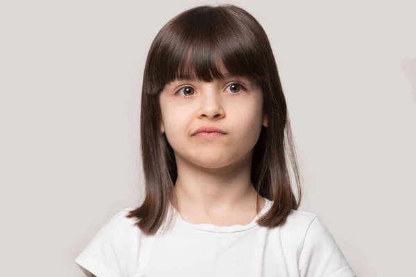 Upset little girl isolated on grey studio background — Stock Photo, Image