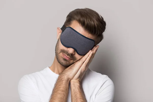 Uomo che indossa maschera dormire su mani piegate studio shot — Foto Stock