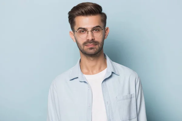 Sério cara vestindo óculos posando isolado no fundo do estúdio azul — Fotografia de Stock