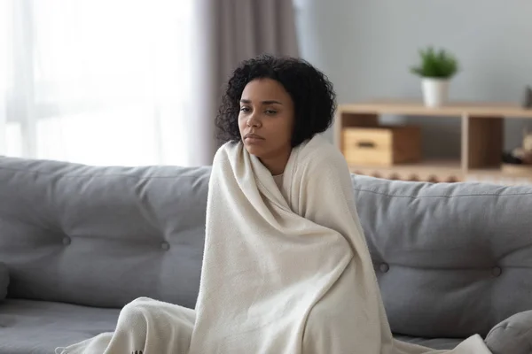 Zieke Afrikaanse vrouw voelt koud bedekt met deken thuis — Stockfoto