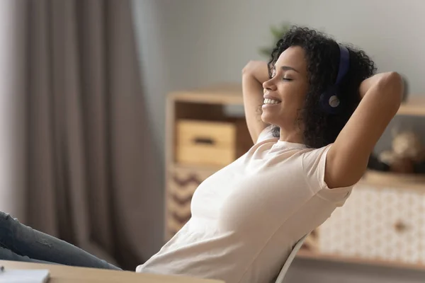 Müzik dinlerken rahatlatıcı kulaklık takan mutlu afrikalı kız — Stok fotoğraf