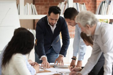 Erkek patron yöneticisi ile çok ırklı iş ekibi insanlar evrak tartışmak