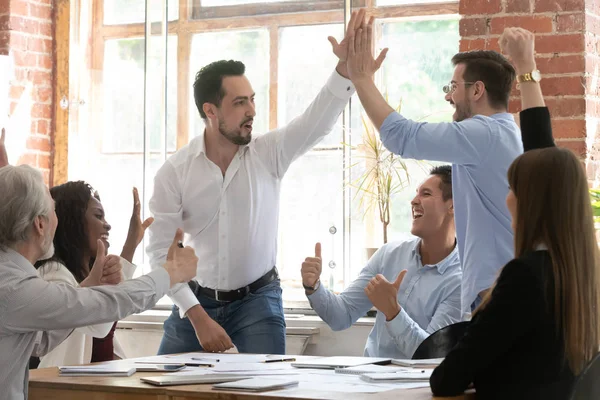 Emocionados compañeros de trabajo alegres dan chocar los cinco en la reunión del grupo — Foto de Stock