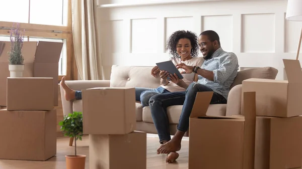 Happy african american couple use digital tablet on moving day — Stock Photo, Image