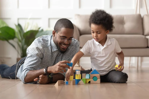 Lycklig afrikansk pappa och barn son Building constructor från block — Stockfoto