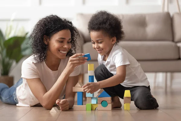 Afrikaanse moeder met weinig Kid zoon spelen met houten blokken — Stockfoto