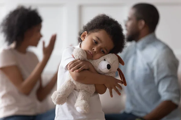 Triste africano niño abrazar juguete molesto por padres discutiendo — Foto de Stock