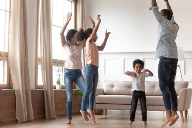 Neşeli mutlu Afrikalı aile birlikte evde atlama eğlenceli