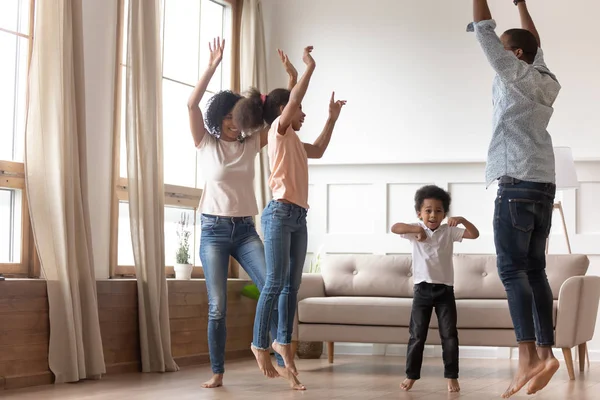 Gioioso felice famiglia africana divertirsi saltando a casa insieme — Foto Stock